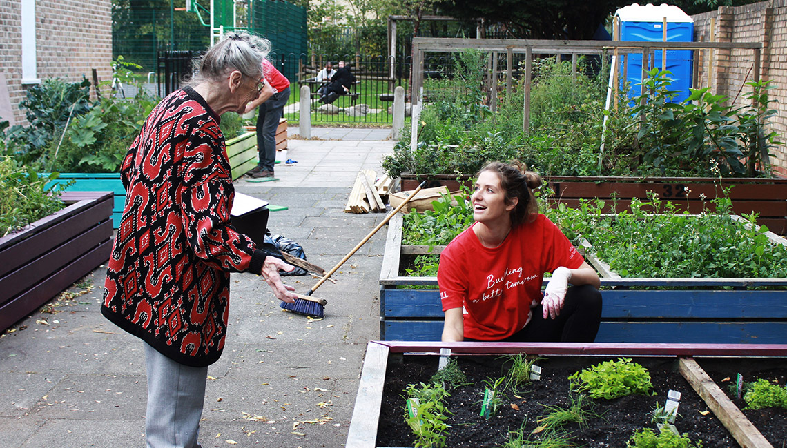 JLL volunteer chatting to resident in London community garden