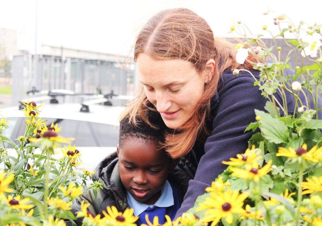 Woman helping young boy in garden