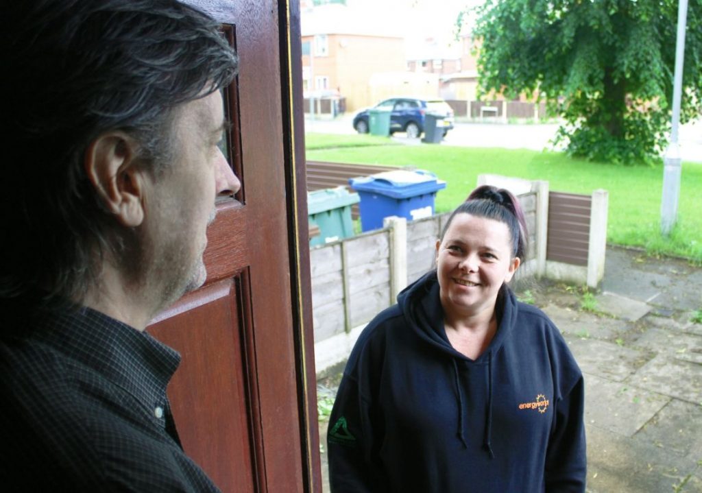 Energyworks employee talking to gentlemen on door step