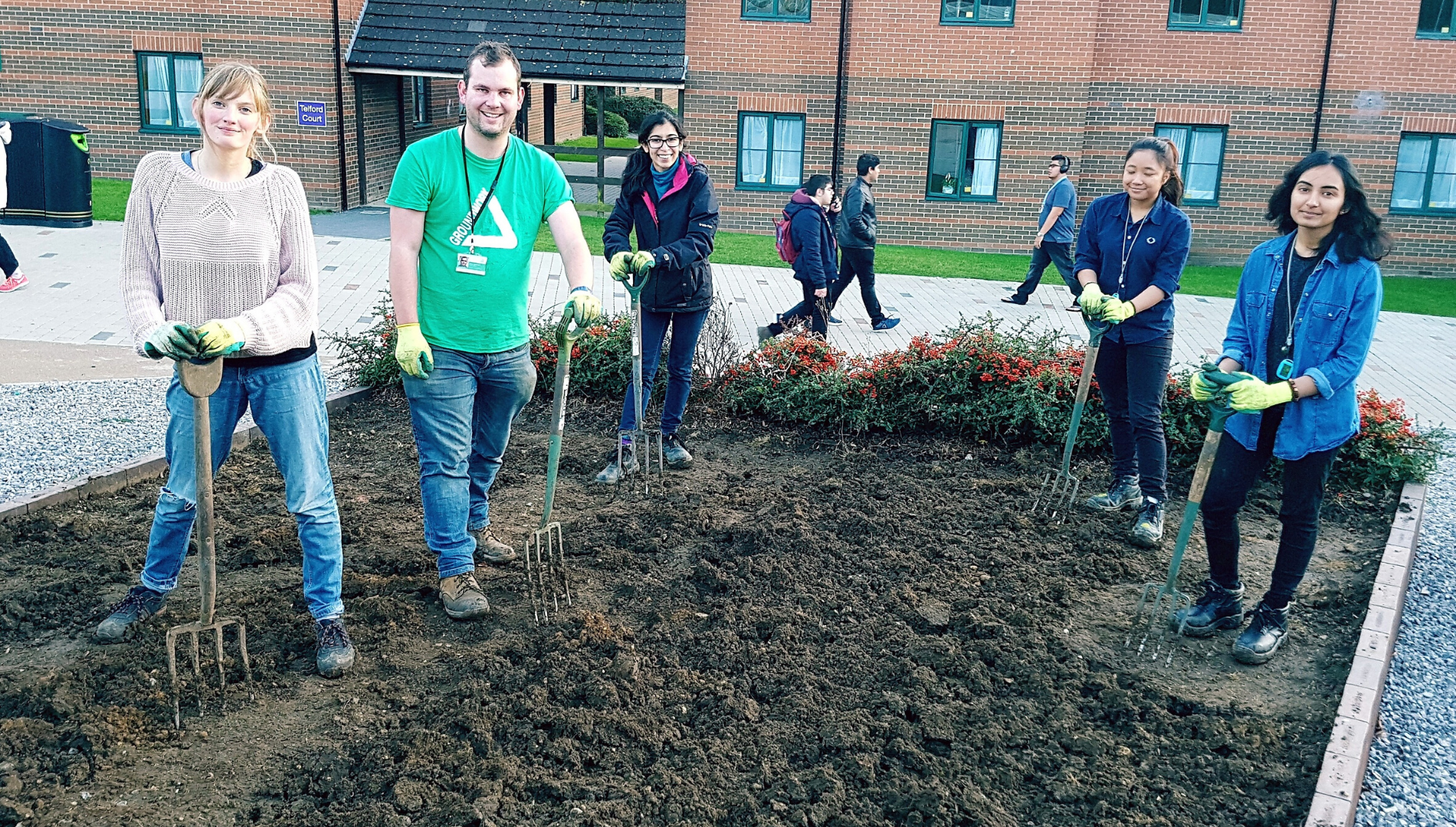 Students with Groundwork staff happily digging