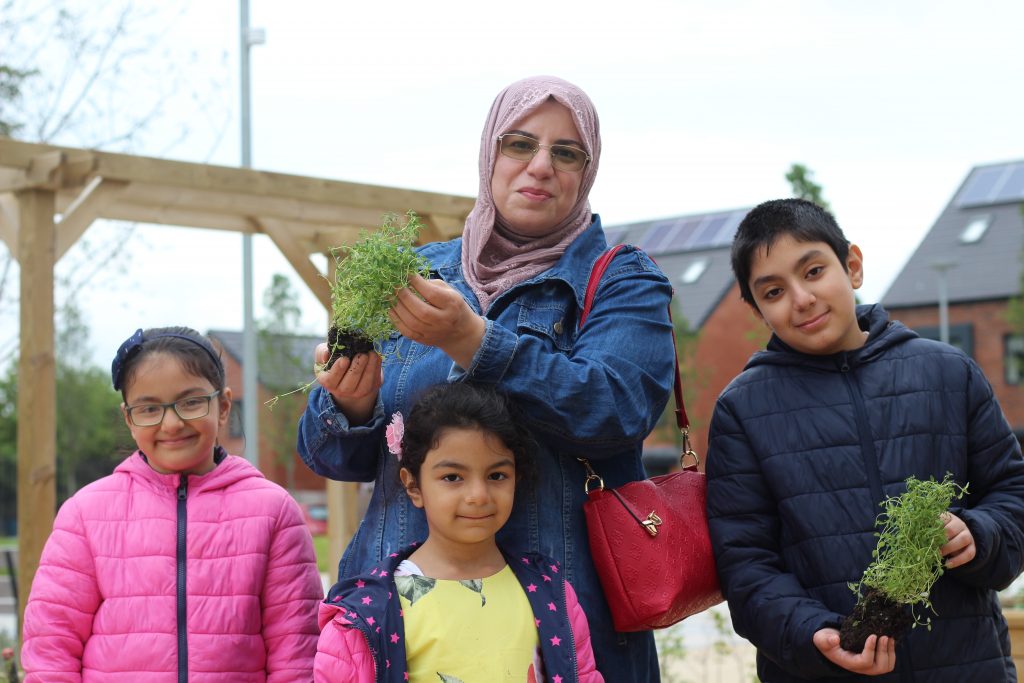 Family holding plants in the park