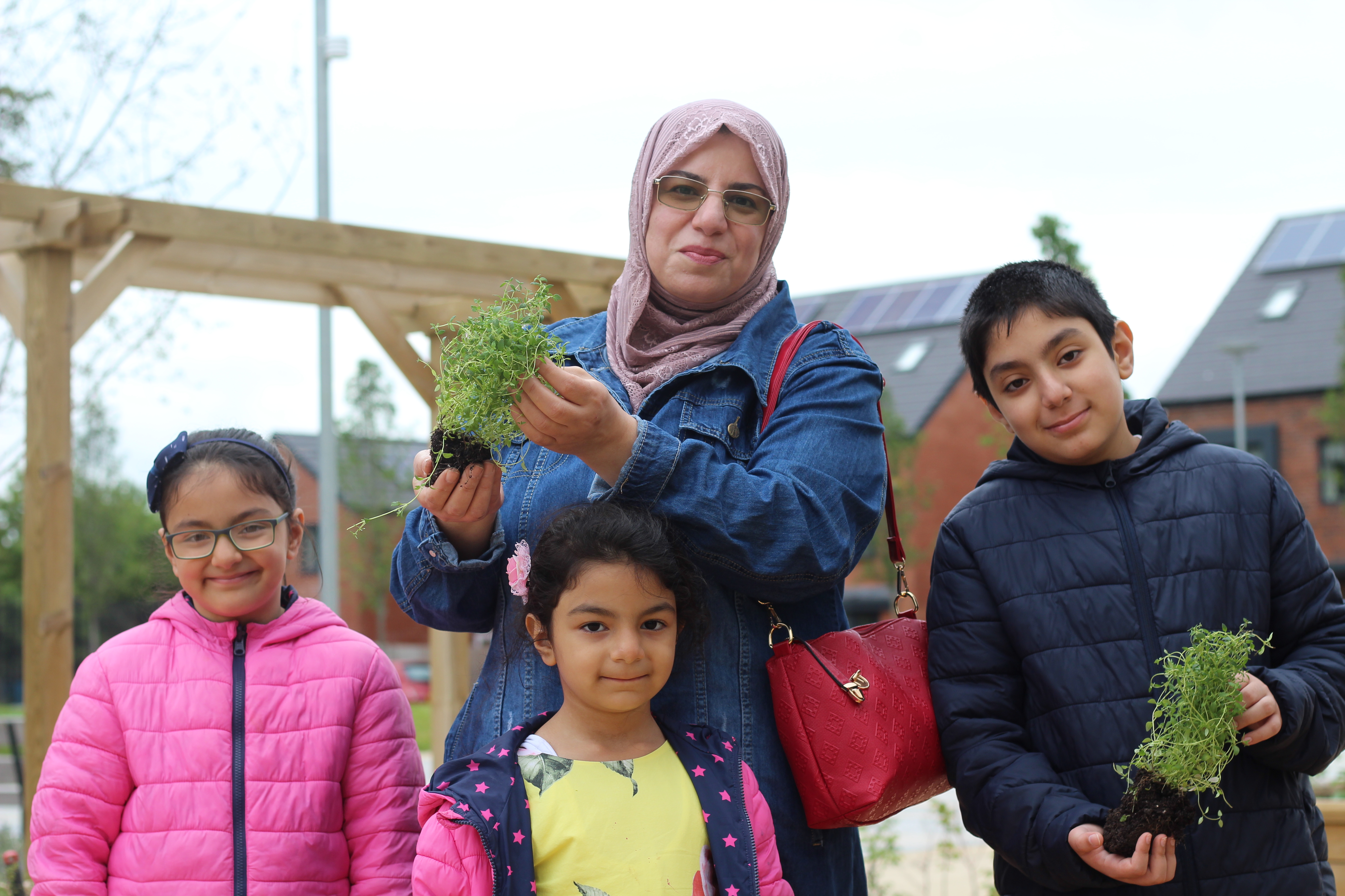 Family holding plants in the park