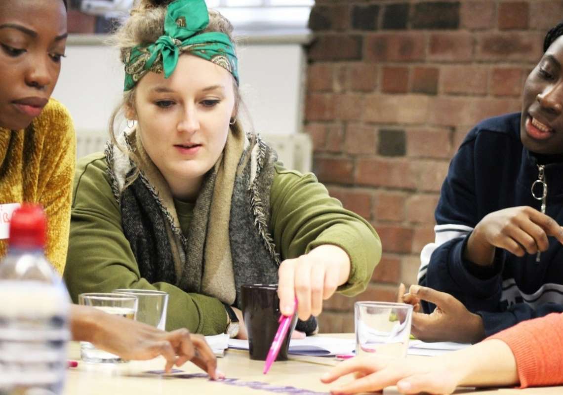 Three young women working together at a table