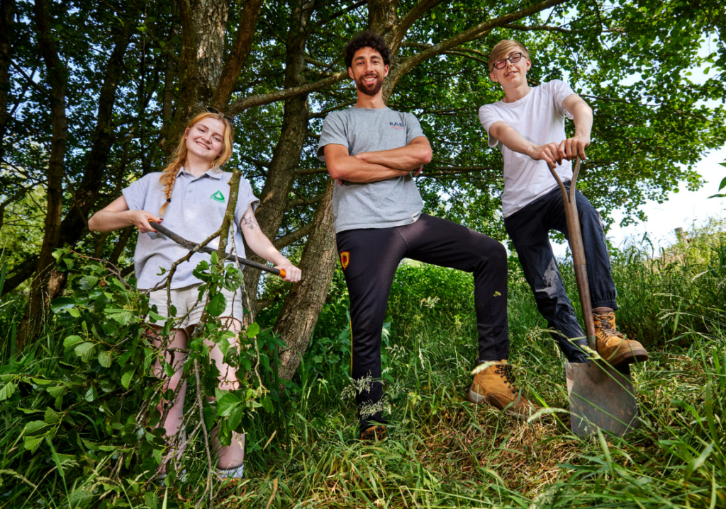 Three young people in a wooded area
