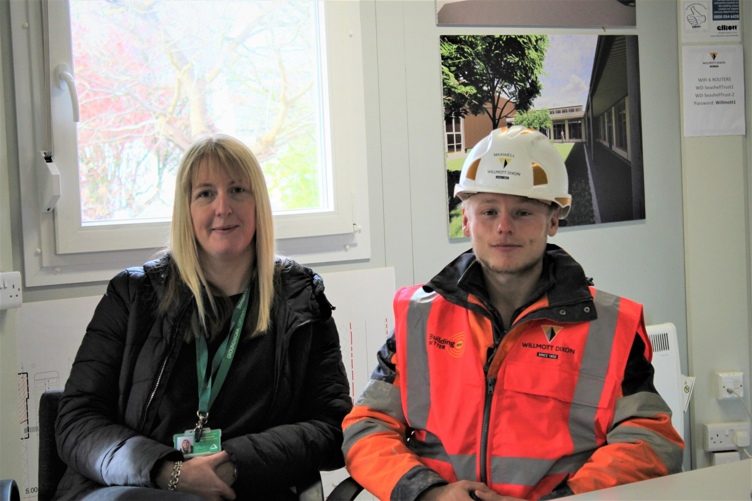 A young person (Max) in his construction uniform, smiling with his mentor.