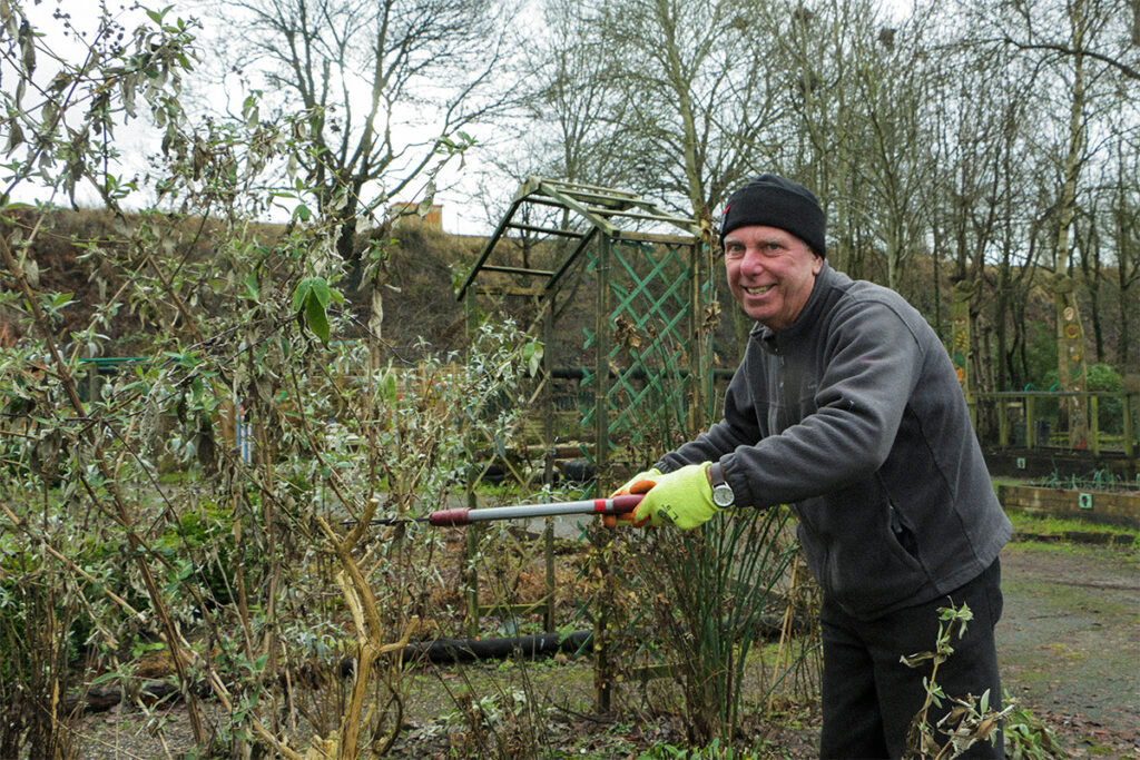 Volunteer Roy pruning bushes at Grozone