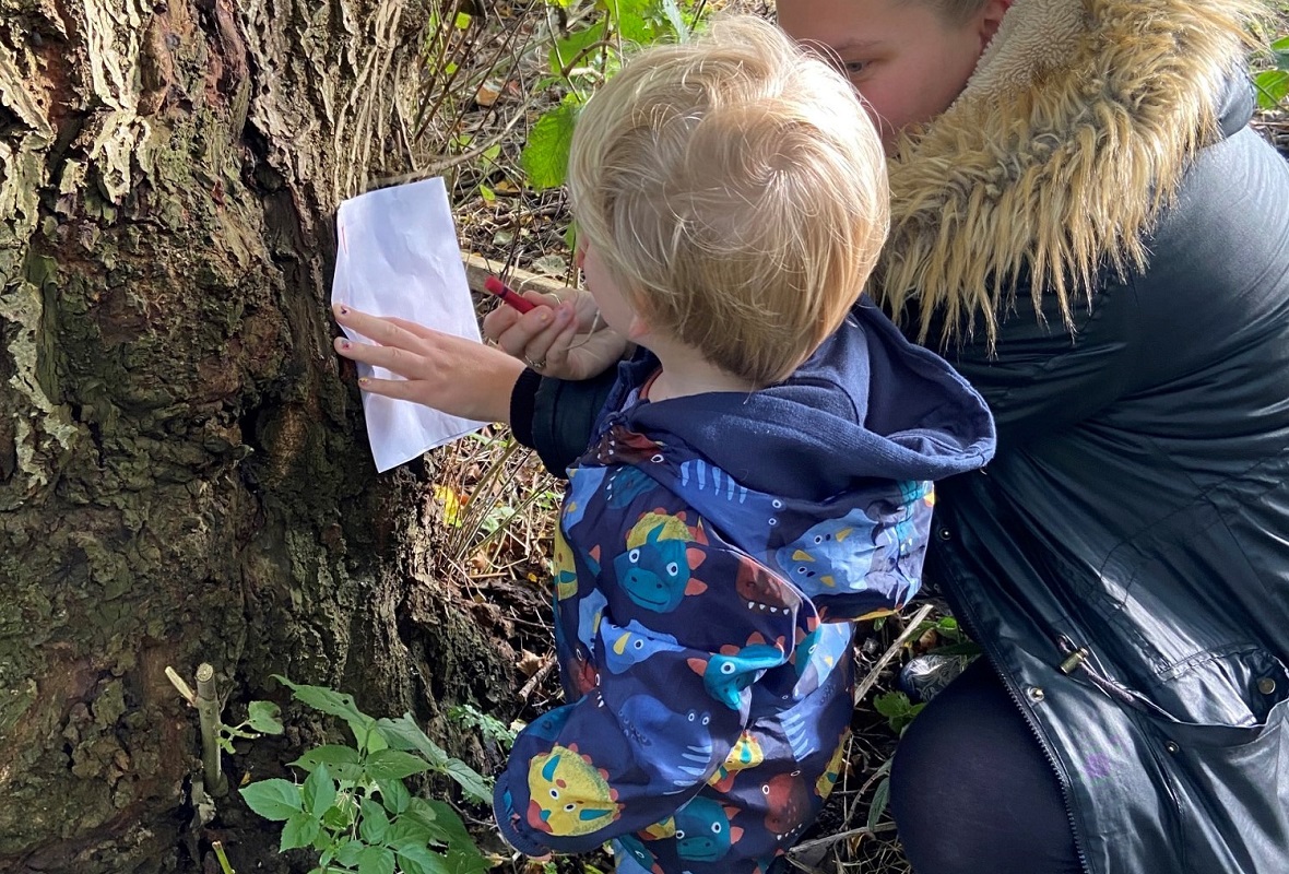 A parent and child drawing on a tree