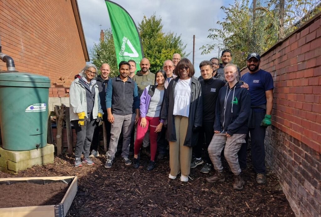 Group of people in a garden all smiling. This photo was taken at the Avision Young Community Day.