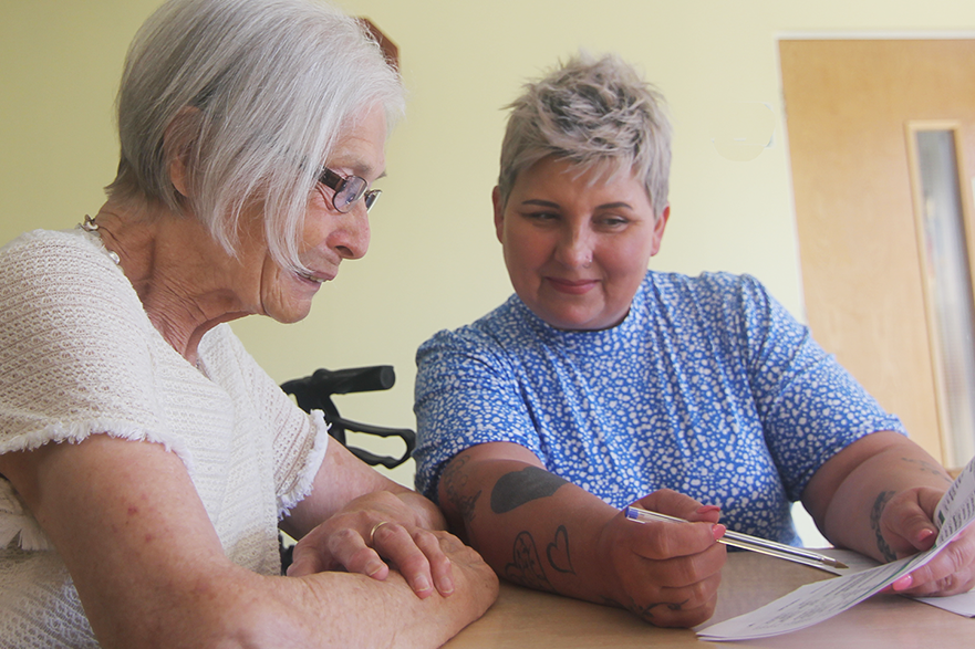 Two women at table looking at paper