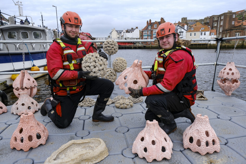 © Tony Bartholomew  /  07802 400651 mail@bartpics.co.uk PICTURE SUPPLIED ON BEHALF OF GROUNDWORK FOR EDITORIAL USE. 29-03-2023 New artificial habitats including a living sea wall, rock pools and hanging fish shelters are being installed at Whitby Harbour on Wednesday 29 March as part of a pilot project to boost biodiversity and improve water quality in the River Esk.  The man-made marine habitats are being created as part of Beach ESK, a partnership project between the Environment Agency, Yorkshire Wildlife Trust and Groundwork North East, supported by private local landowners, Scarborough Borough Council and Yorkshire Water. Seen here are Ethan Salter (left) and Harvey Smith who work as rescue technicians for Swiftwater Solutions