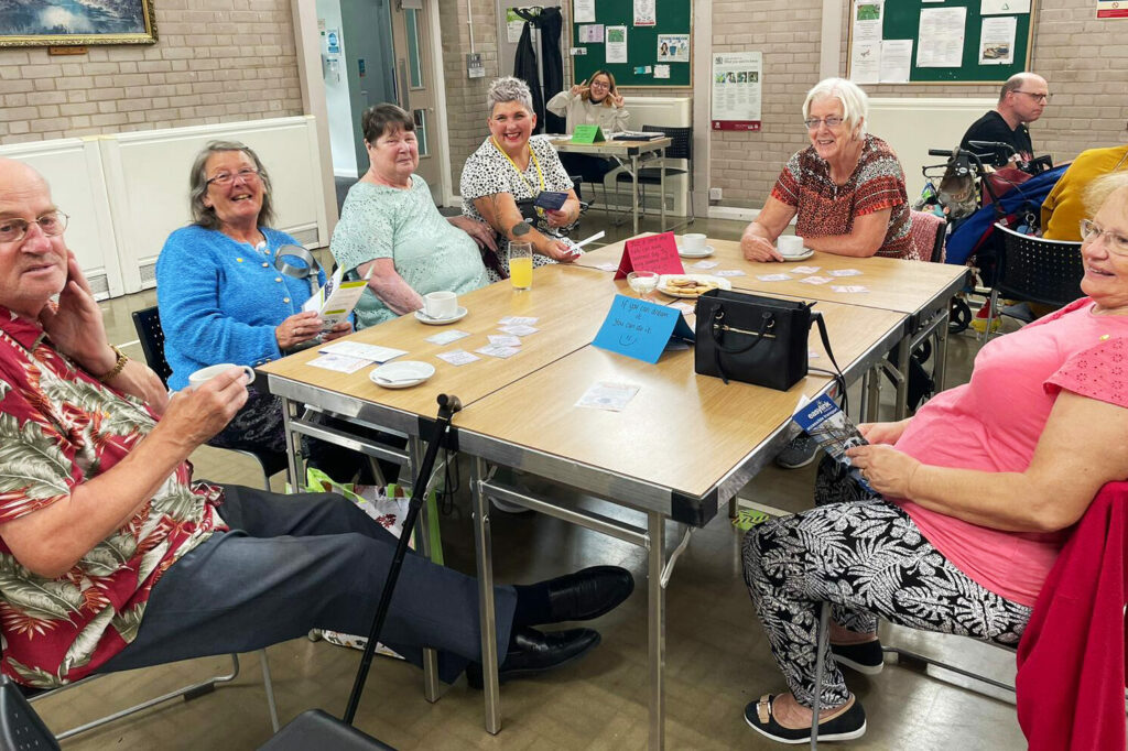 Group of people sitting at table during Smile Wellbeing event in Nottingham