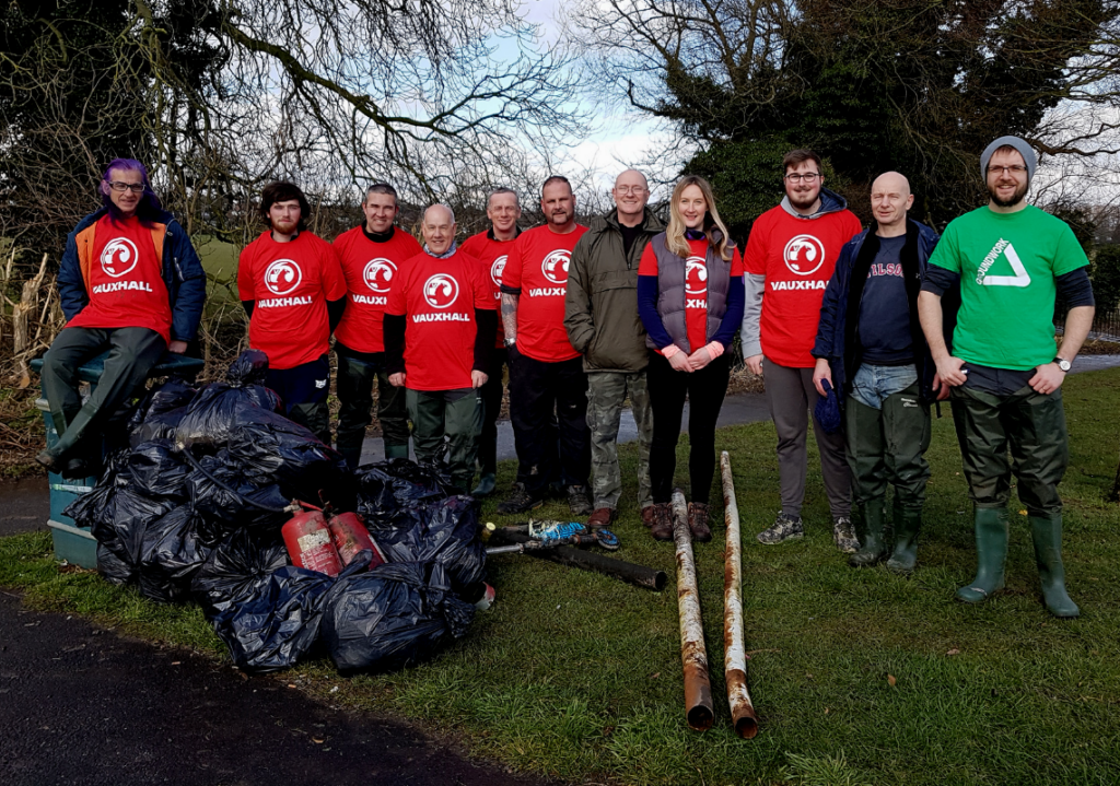 Volunteers in a group outside smiling after a day's gardening