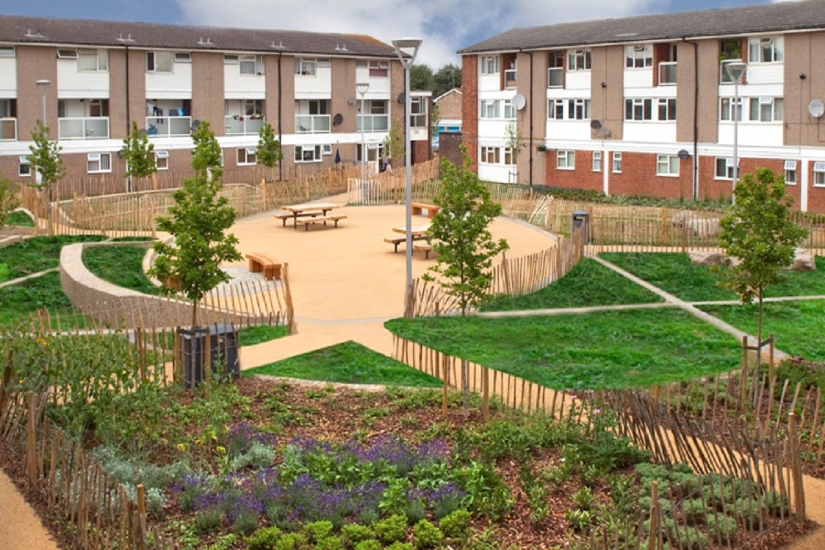 Landscaped coutryard between houses showing flower beds, pathways and allotments