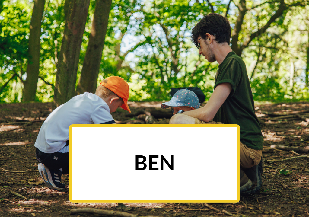 Trainee Ben kneels in woodland with two children 