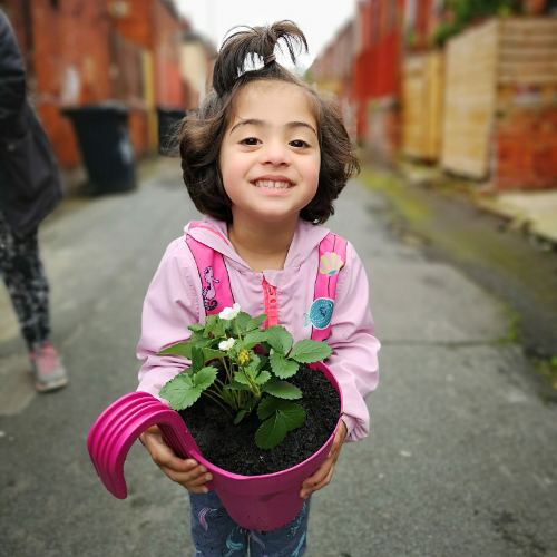 Young girl holding potted plant