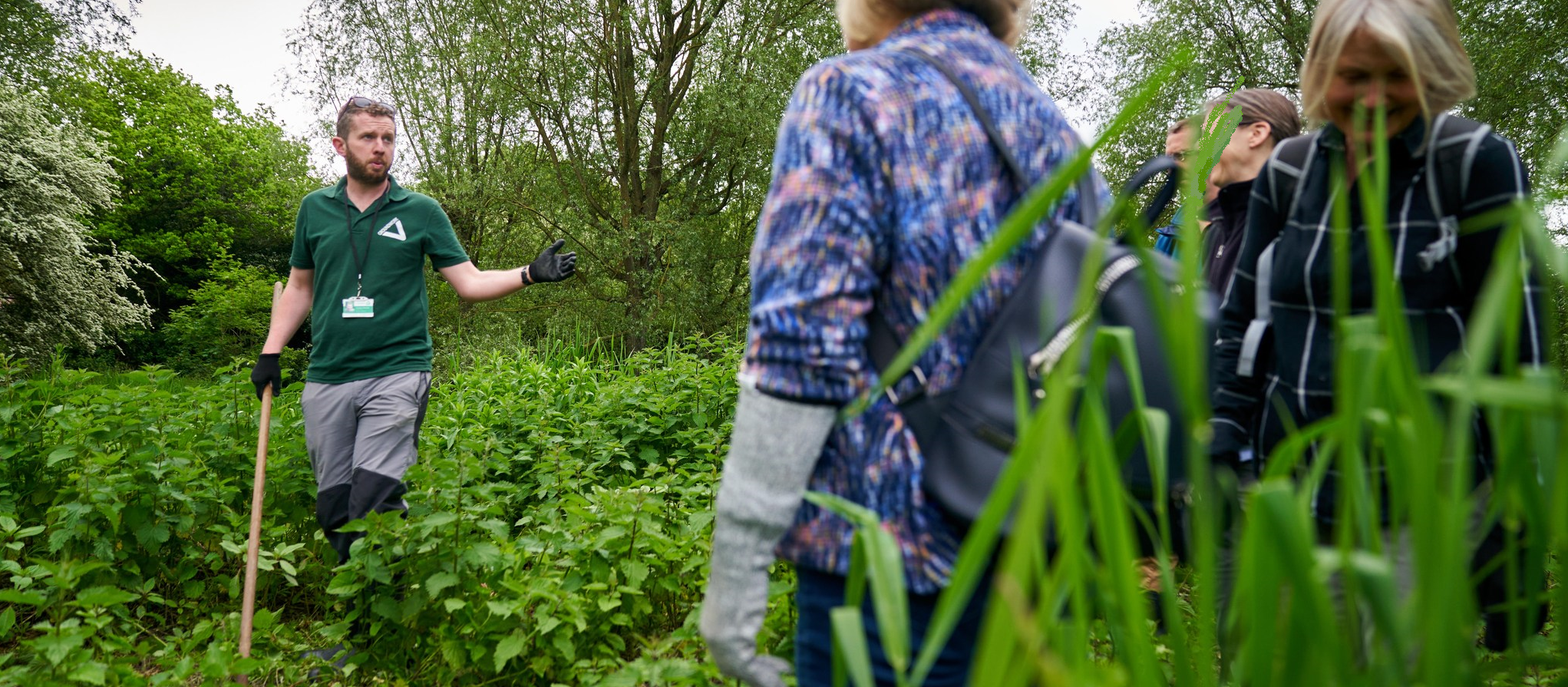 Project Officer talking to volunteers about plants on the River Colne
