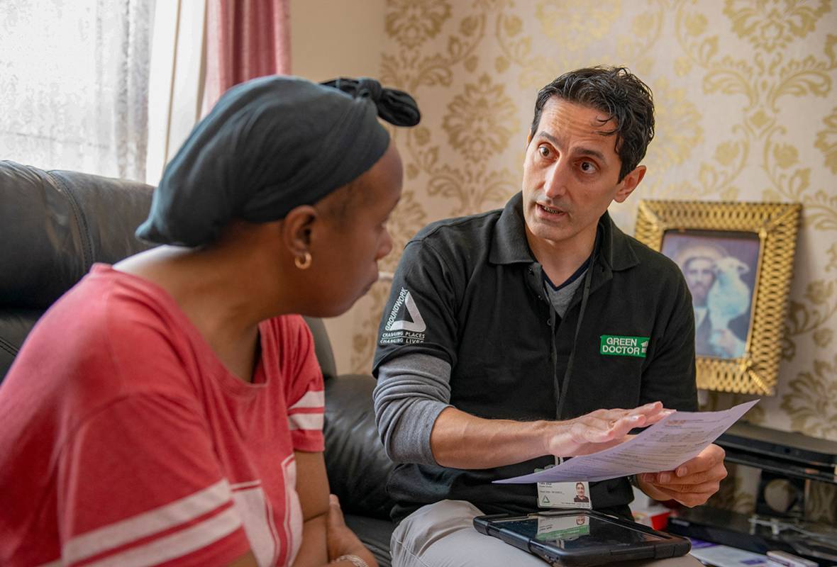Photo of a Groundwork Green Doctor assisting a woman in her home.