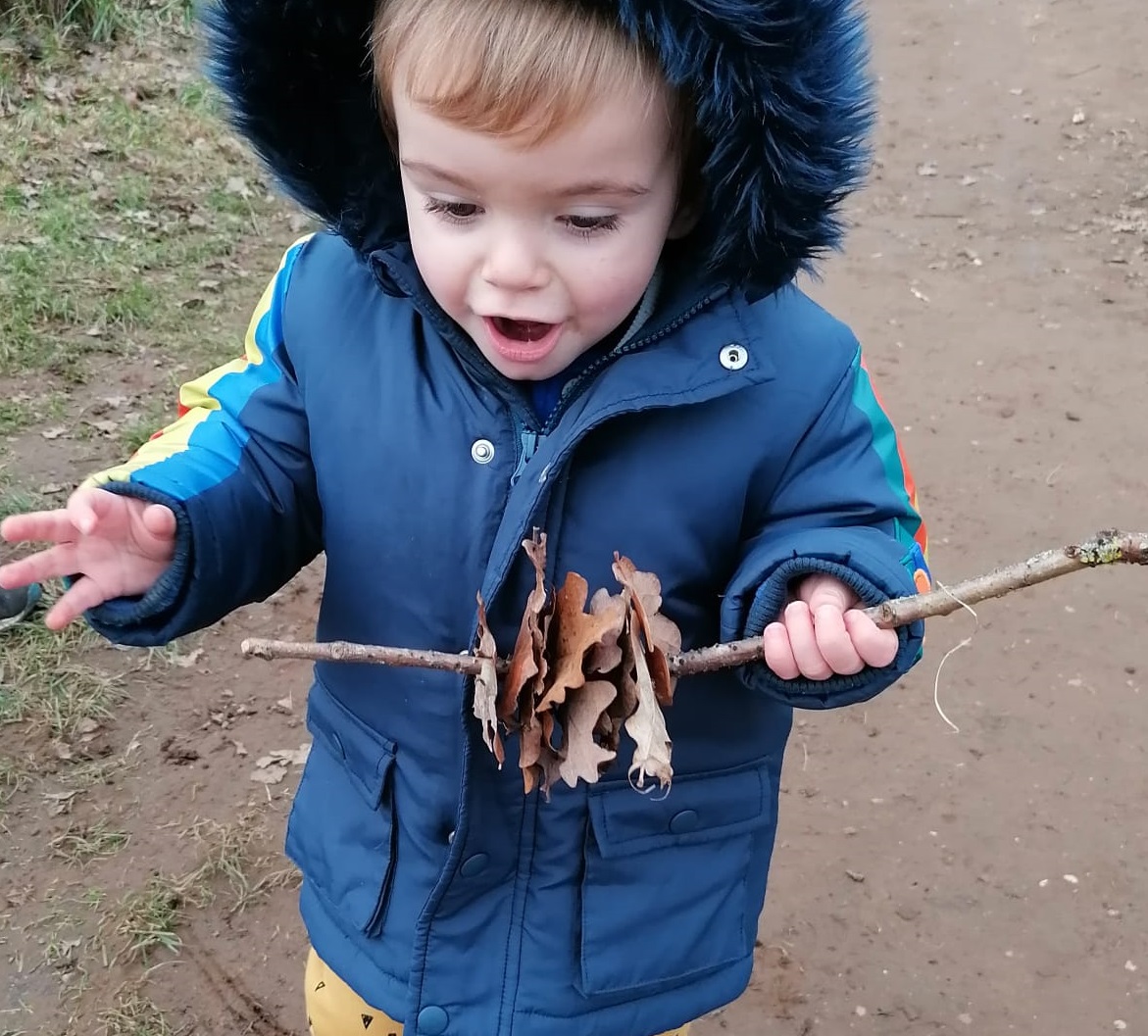 little boy excited with leaves playing outside