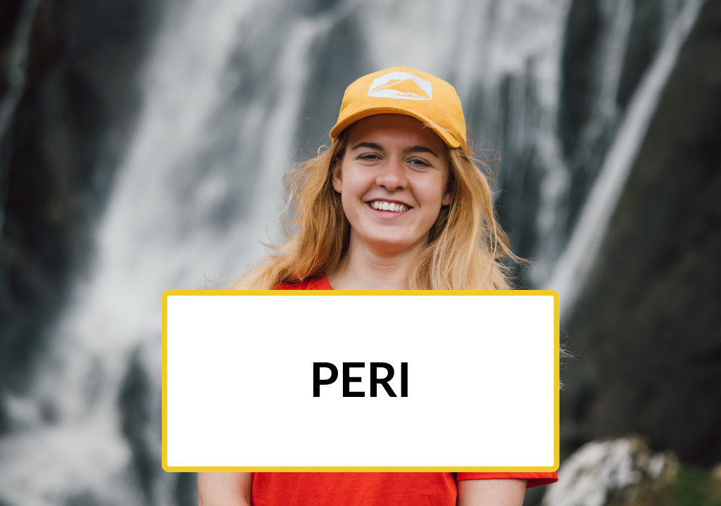 Trainee Peri stands in front of a waterfall.