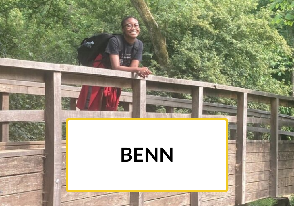 New to Nature Trainee, Ben, smiling on a bridge outdoors.