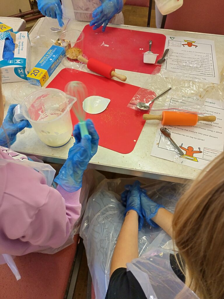 Children preparing food items with gloves and apron on