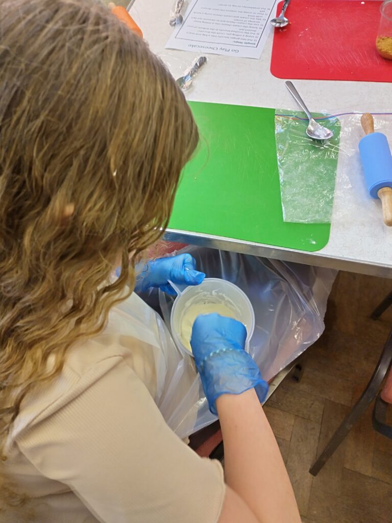 A child mixing cake mixture in a jug