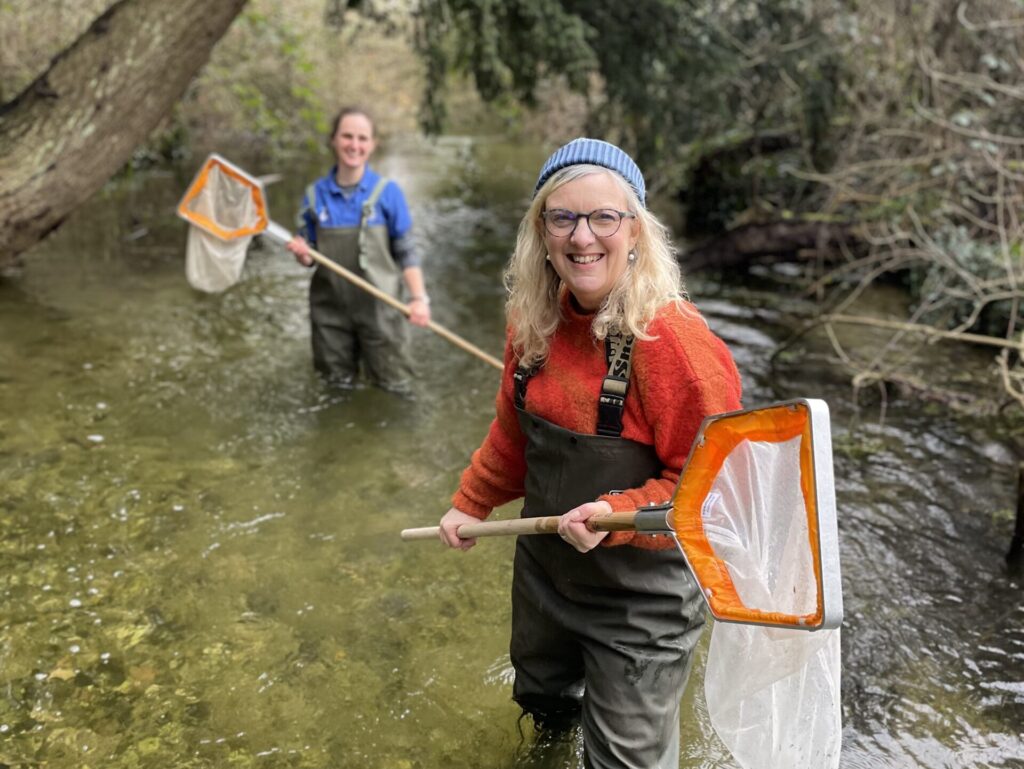 Two women cleaning a river