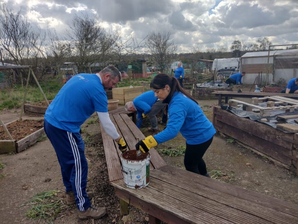 Two people painting a bench