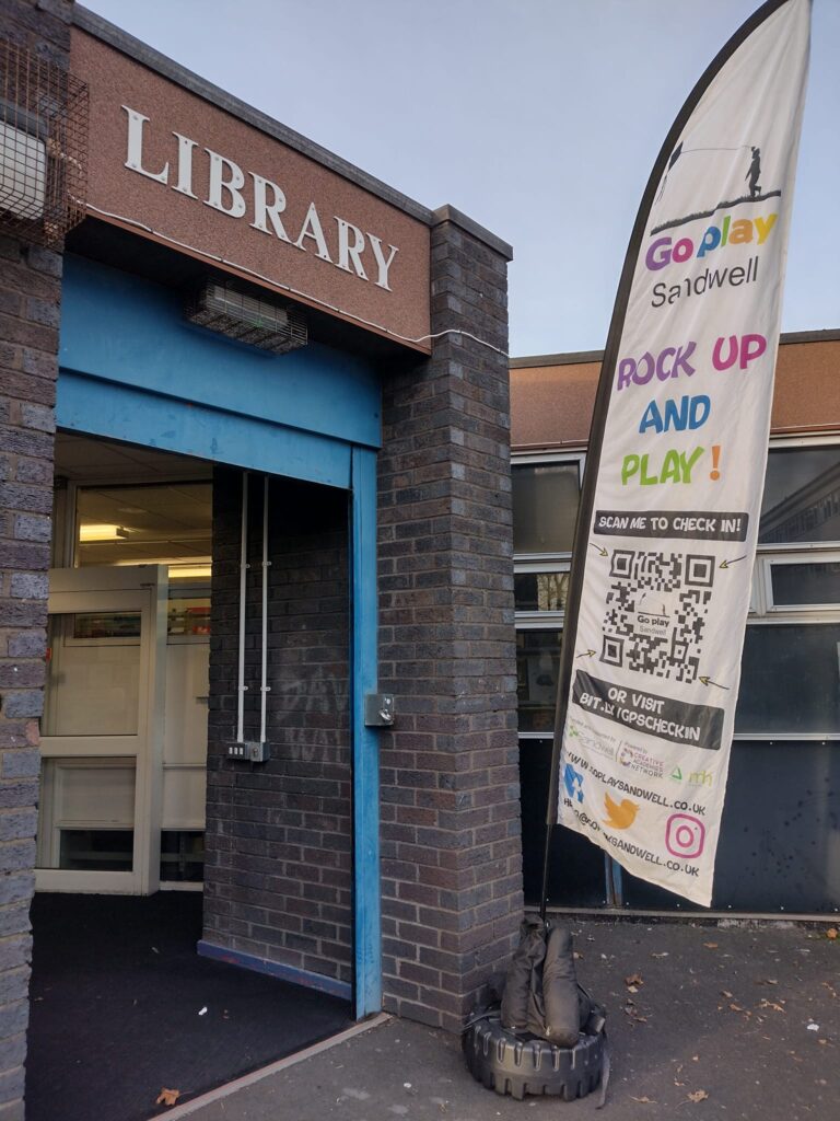 outside of a library with a Go Play flag outside