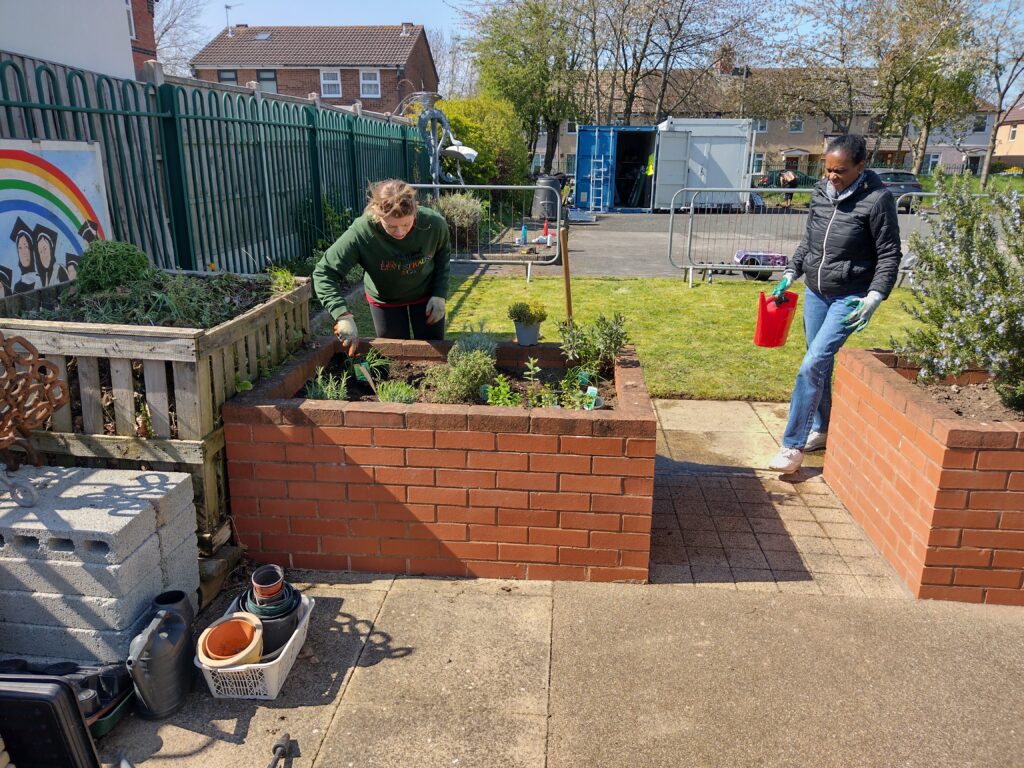 Two people watering plants