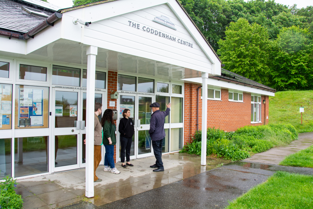 people talking in front of village hall