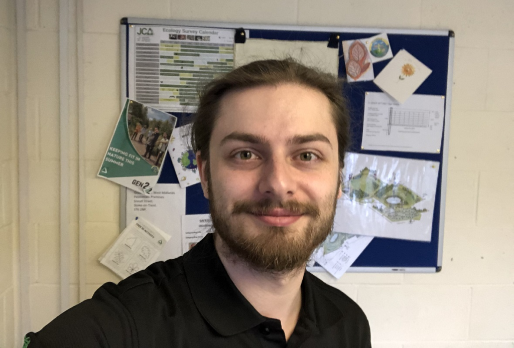 Aman taking a selfie with a noticeboard in the background