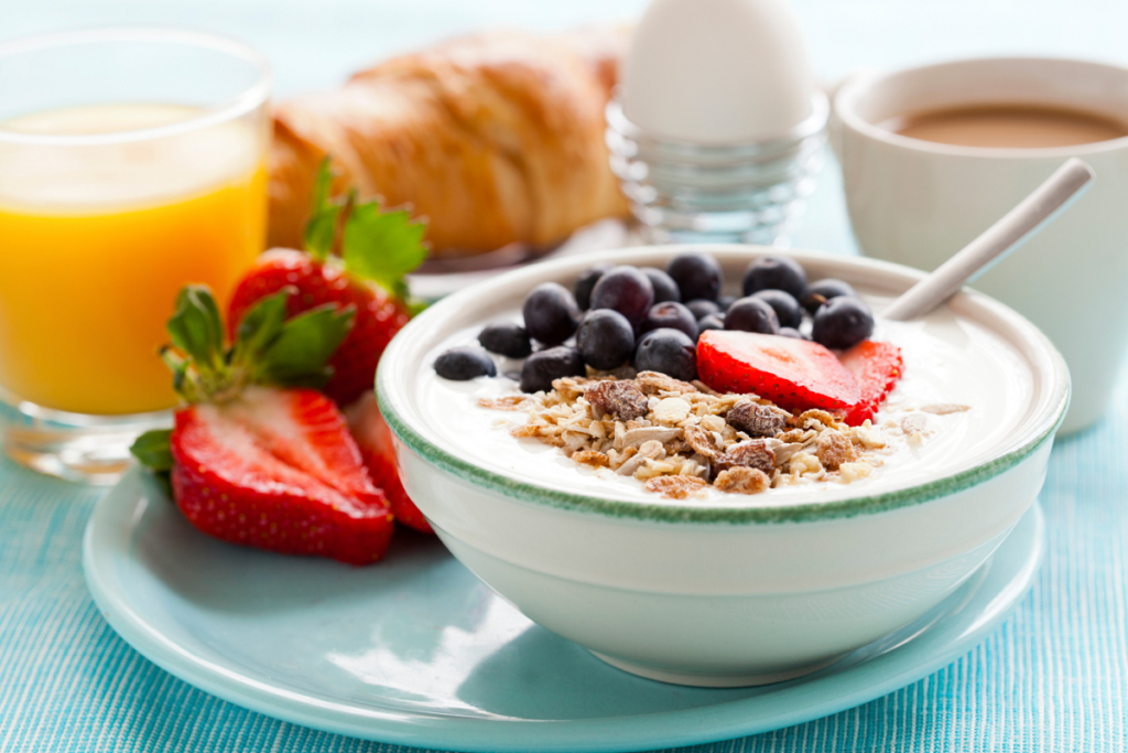 Bowl of cereal and fruit with a glass of orange juice