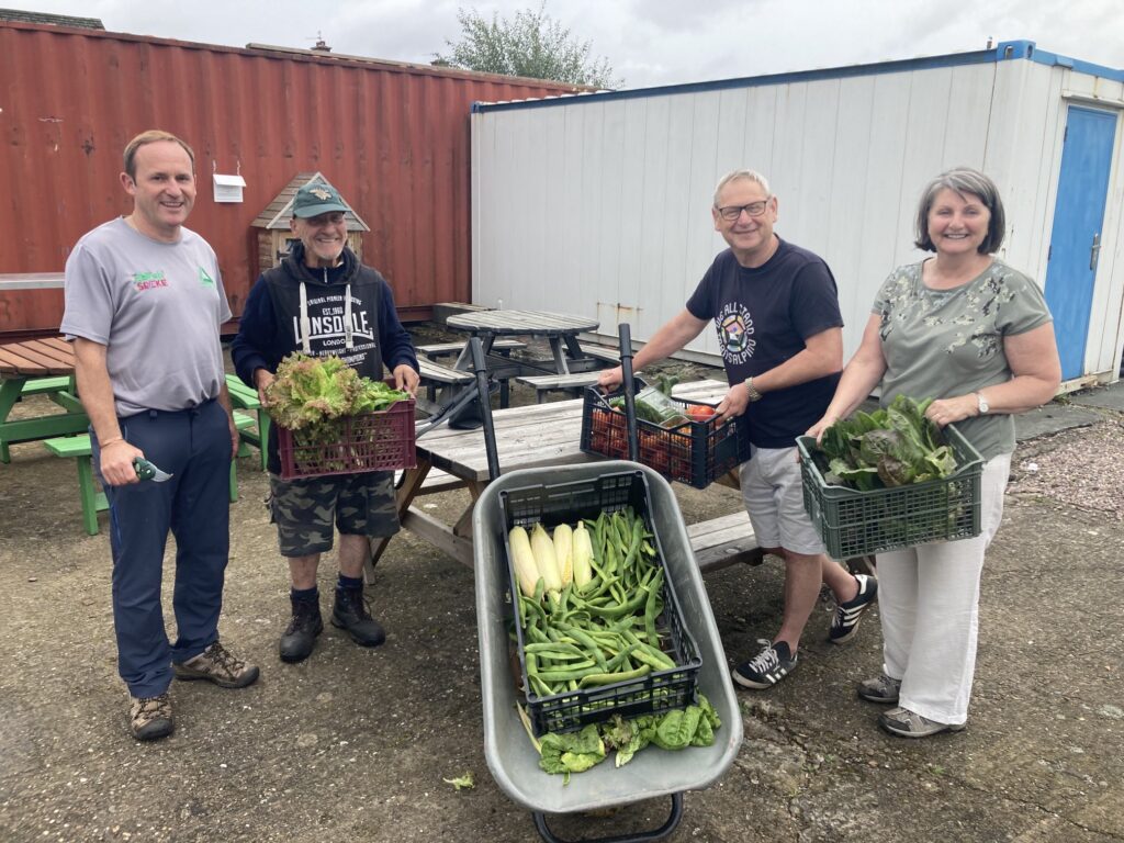 Staff and volunteers with produce grown on site