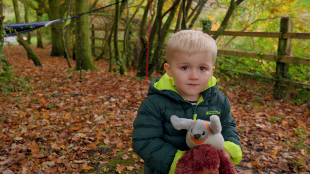 Photo of a child outdoors holding a teddy bear