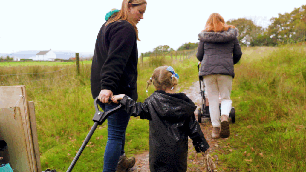 Photo of Hannah walking with children pulling a wagon on an outdoor trail
