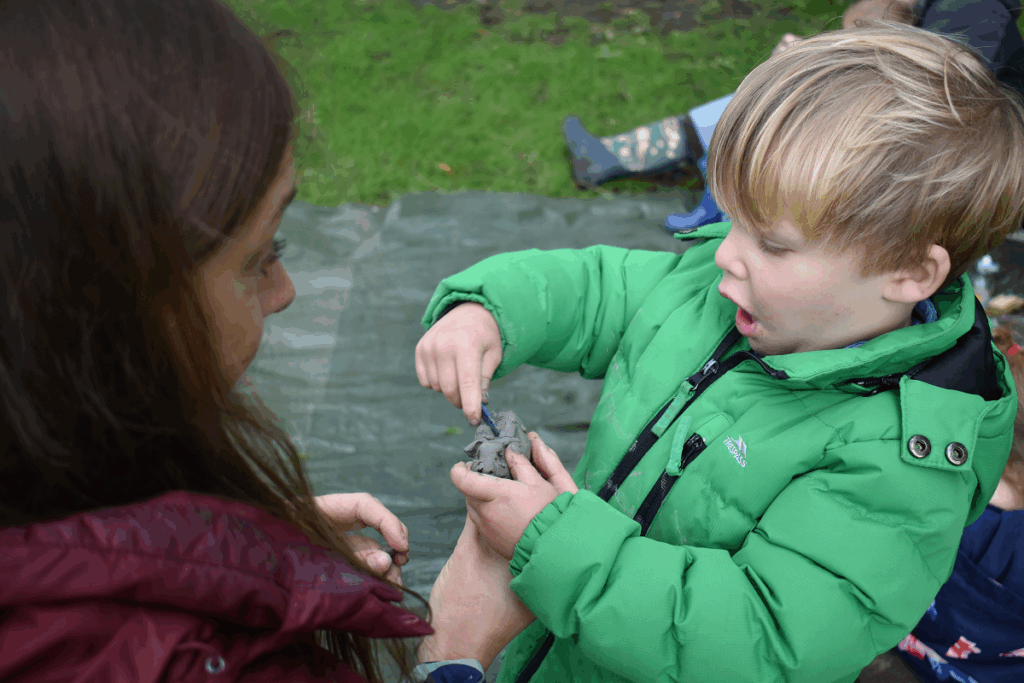 Child playing with clay outside