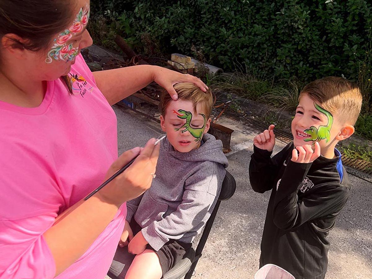 Two young boys get their faces painted.