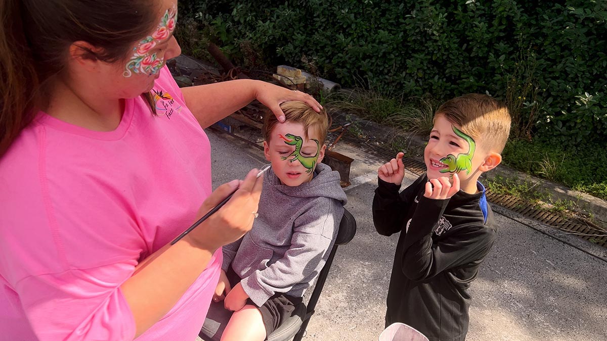 Two male children get their faces painted at the Summer Festival 