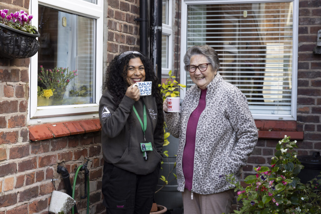 Green doctor having a cuppa with a client in the garden