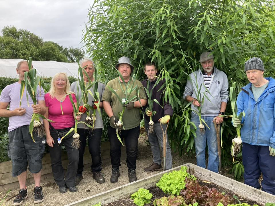 Volunteers holding up the latest crop of onions.
