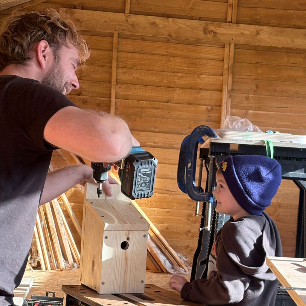 Man and young boy working on bird house