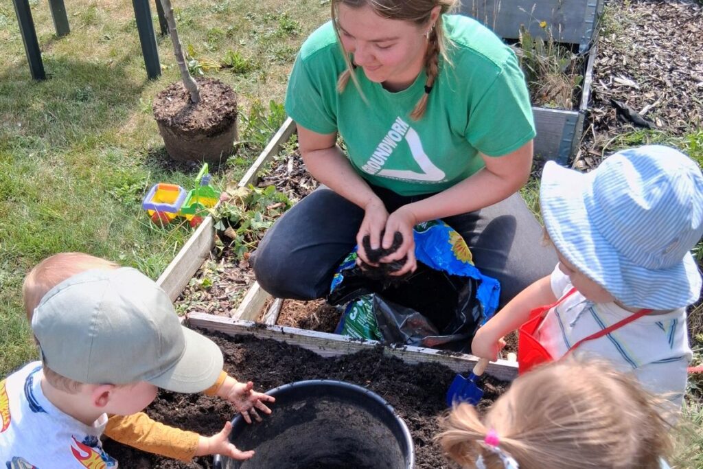 Children planting trees in a garden