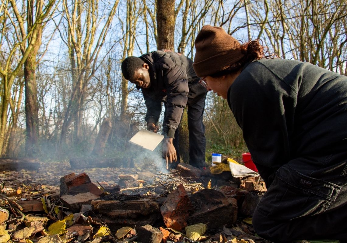 Young people starting a fire