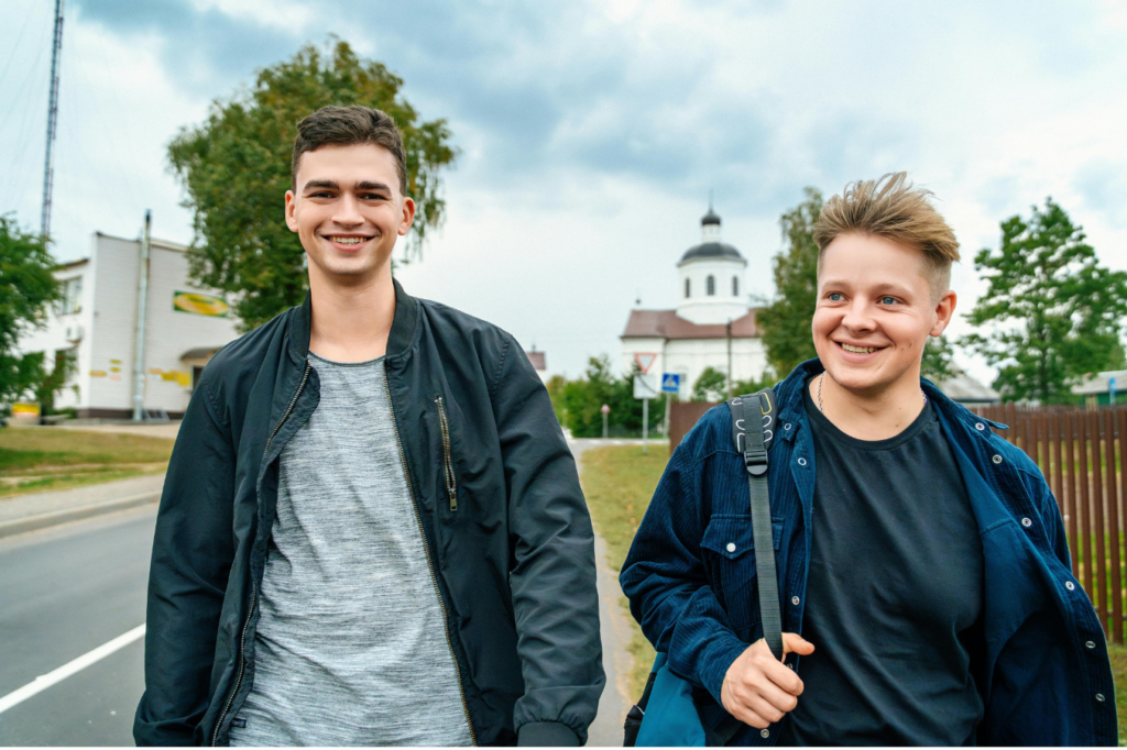 Two teenagers smiling whilst they walk along a path
