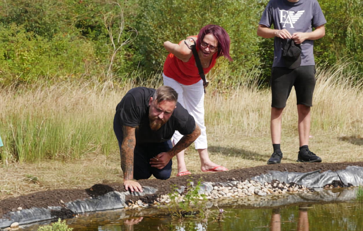 People looking into a pond wildlife