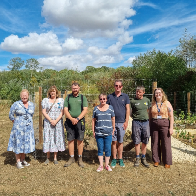 Group of people smiling in front of a green area
