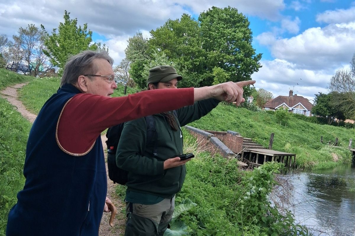 2 men pointing across the river colne