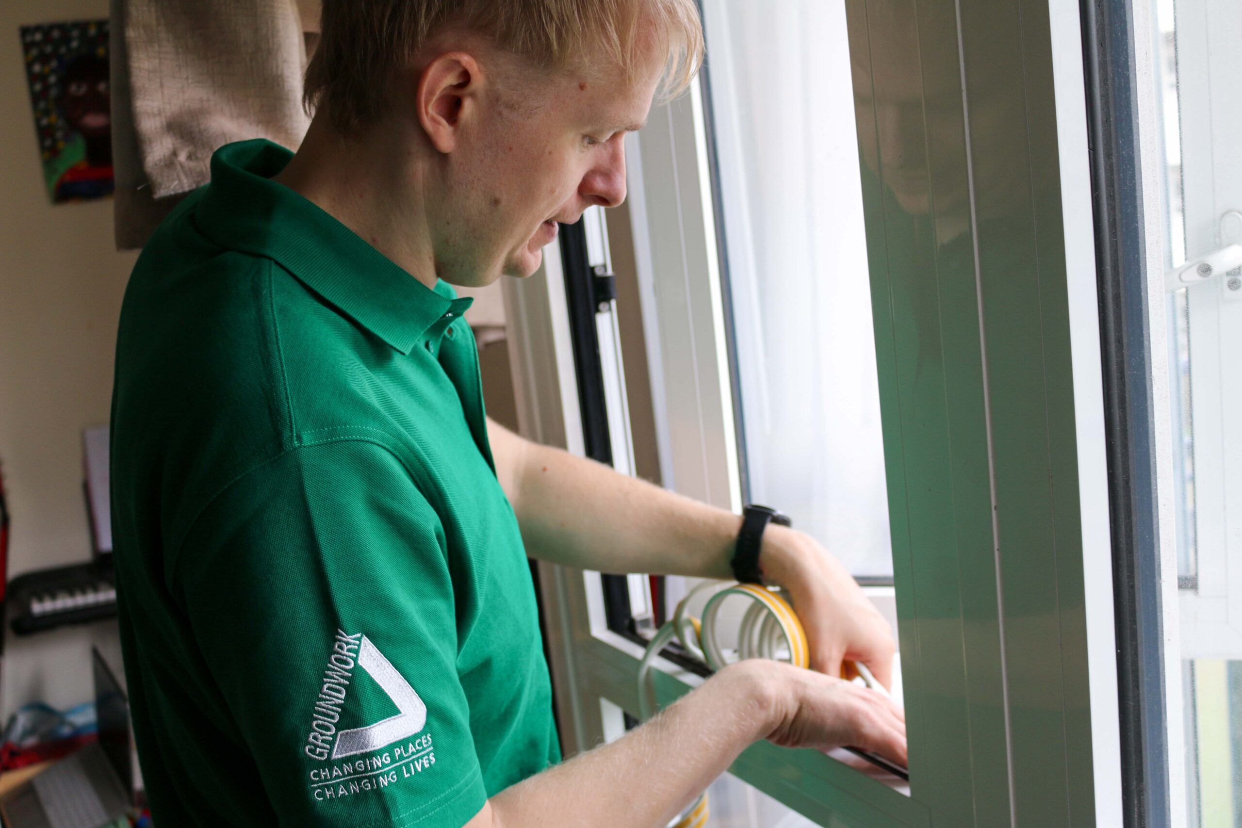 Daniel Brittle adding draft proofing to a window