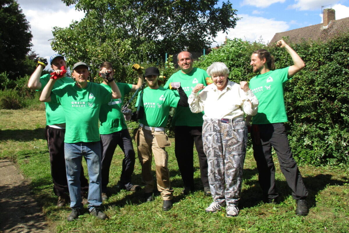 Green aider volunteers in a garden smiling